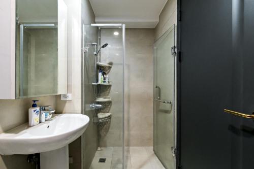 a bathroom with a glass shower and a sink at Makati City Centre Condo in Manila