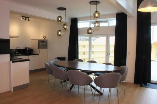 a dining room with a table and chairs at Groepsverblijf het Uilennest in Hommerts