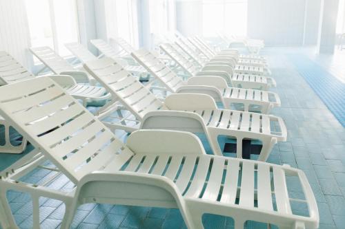 a row of white chairs in a room at Hotel Dobsi in Bazna