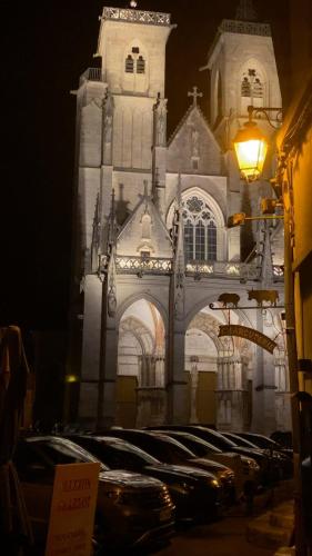 a large building with a clock tower at night at La Perle Semuroise in Semur-en-Auxois