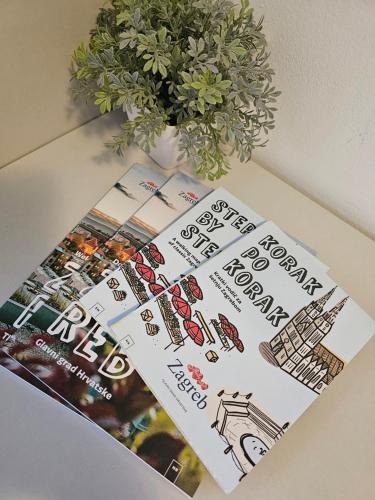 a book sitting on a table next to a plant at Filipovic rent a car & apartments in Selnica Šćitarjevska