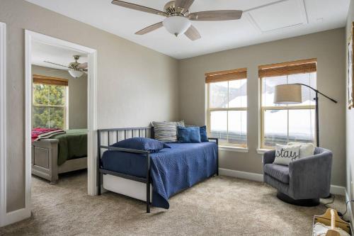 a bedroom with a bed and a chair and windows at Timber Court in Granby