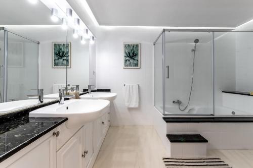 a white bathroom with two sinks and a shower at Charming 4 Double Bed Steps from the Old Town in Bilbao