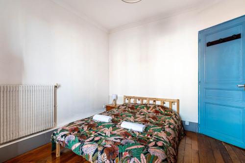 - une chambre avec un lit et une porte bleue dans l'établissement GuestReady - La Villette Comfort, à Aubervilliers