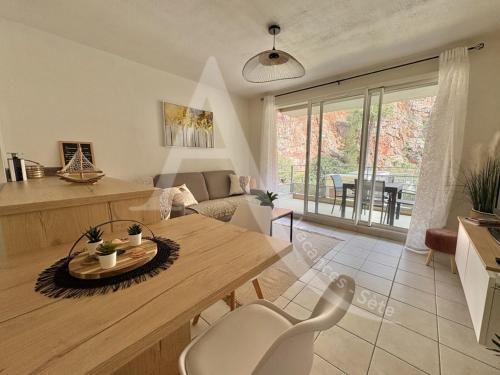 une cuisine et un salon avec une table et des chaises dans l'établissement T3 renove dans residence avec piscine et garage Capacite max 6 personnes, à Sète