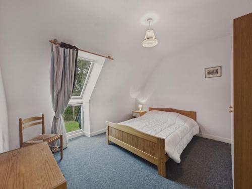 une chambre avec un lit, une table et une fenêtre dans l'établissement Maison avec jardin pour 8 adultes et 2 enfants, à La Forêt-Fouesnant