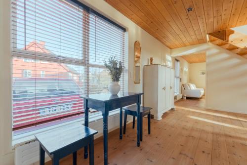 een eetkamer met een blauwe tafel en een groot raam bij 3 BR House - Parking - 10min walk from city centre in Tórshavn