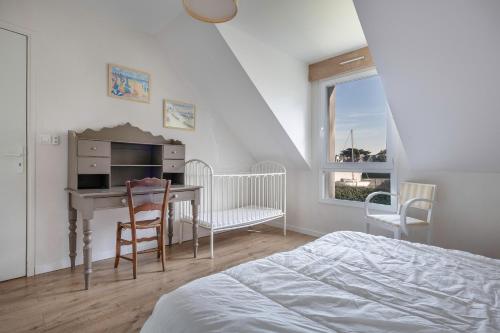 a bedroom with a desk and a bed and a table at A 150m de la plage, jolie maison avec jardin pour 10 in Saint-Sébastien