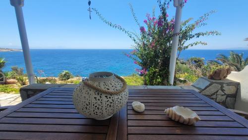 a wooden table with a vase and seashells on it at Akrogiali studios in Donoussa