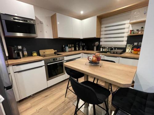 - une cuisine avec une table en bois et un bol de fruits dans l'établissement Appartement avec Clim et balcon, au Grau-du-Roi