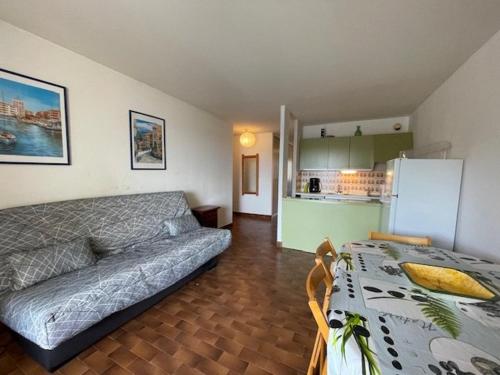 un salon avec un canapé et une table et une cuisine dans l'établissement 124 Pharo D308, au Cap d'Agde