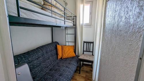 - une petite chambre avec des lits superposés et une chaise dans l'établissement 049 Beau studio cabine quartier falaises avec parking, au Cap d'Agde