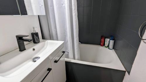 une salle de bain avec un lavabo, une baignoire et une douche dans l'établissement 049 Beau studio cabine quartier falaises avec parking, au Cap d'Agde