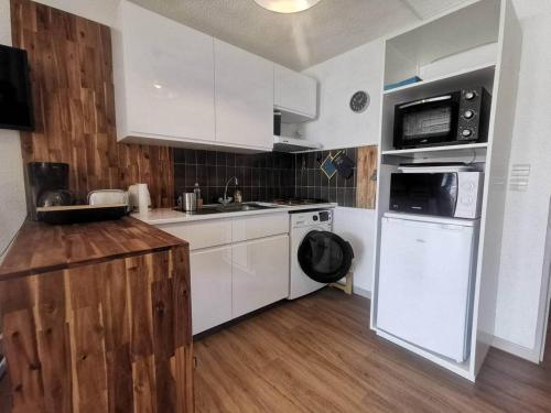 une cuisine avec des appareils blancs et un parquet dans l'établissement 137 Indes Galantes E261, au Cap d'Agde