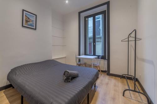 une chambre avec un lit avec un chapeau dessus dans l'établissement Royal Suite - Villeurbanne centre, à Villeurbanne