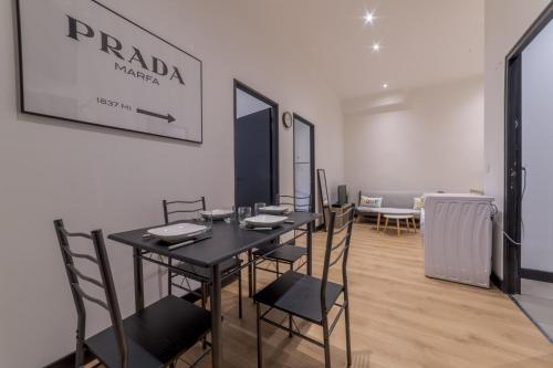une salle à manger avec une table et des chaises noires dans l'établissement Royal Suite - Villeurbanne centre, à Villeurbanne