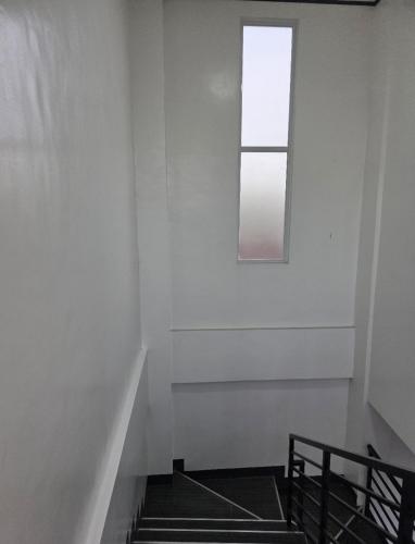a stairway with a window and a white wall at Mamadear's Bed & Breakfast in Suizo