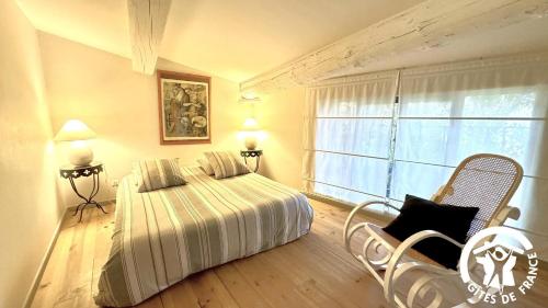 une chambre avec un lit et une grande fenêtre dans l'établissement Gîte Brassens, à Pouzols-Minervois