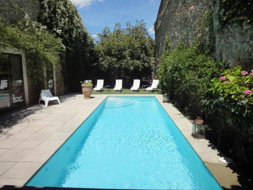 - une piscine avec des chaises longues dans la cour dans l'établissement Gîte Brassens, à Pouzols-Minervois