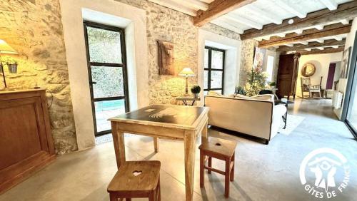 un salon avec une table et un piano dans l'établissement Gîte Brassens, à Pouzols-Minervois