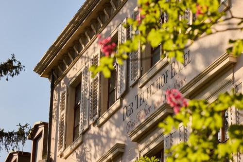a building with windows and flowers on the side of it at Gast - und Kulturhaus Der Teufelhof Basel in Basel
