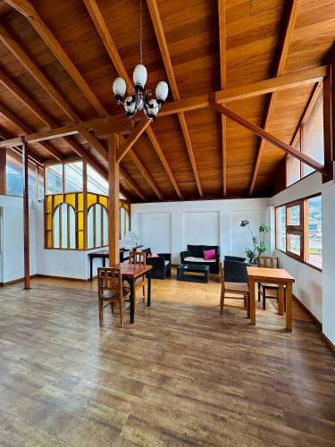 a large living room with wooden ceilings and tables at Rajutuna Inn in Huaraz