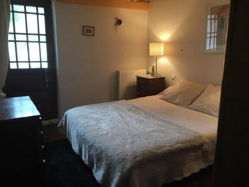a bedroom with a white bed and a window at Les volets bleus in Les Angles