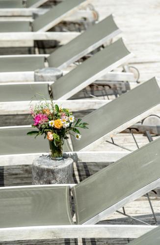 a vase of flowers sitting in a row of chairs at Hotel Valentinerhof in Siusi