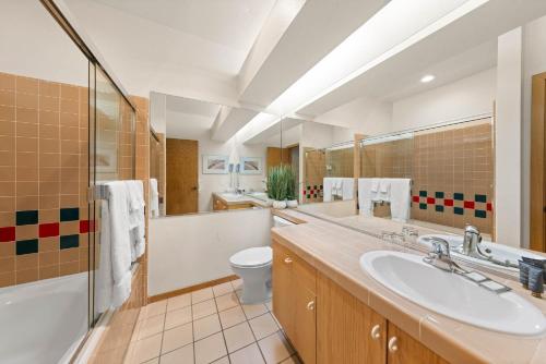 a bathroom with a sink and a toilet and a mirror at Palisades Tahoe Lodge Rentals Studio #256 in Olympic Valley