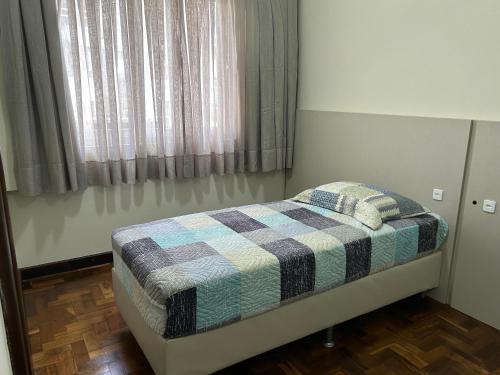 a small bed in a room with a window at POSIT APARTAMENTOS in Curitiba