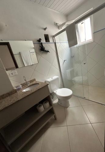 a bathroom with a toilet and a sink and a shower at POSIT APARTAMENTOS in Curitiba