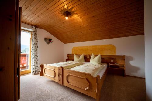 - une chambre avec un lit en bois et un plafond en bois dans l'établissement Ferienwohnung Triembachhof, à Schönau am Königssee