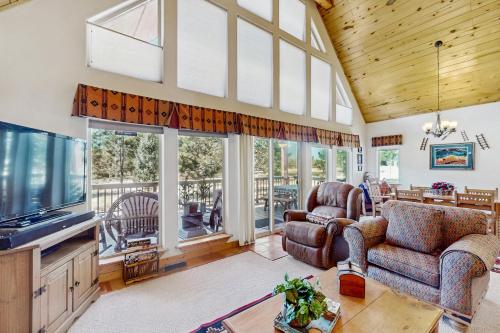 a living room with a flat screen tv and furniture at Painted Pony Cabin in Angel Fire