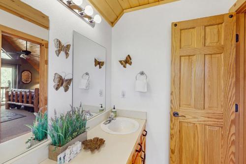 a bathroom with a sink and a mirror with butterflies on the wall at Painted Pony Cabin in Angel Fire