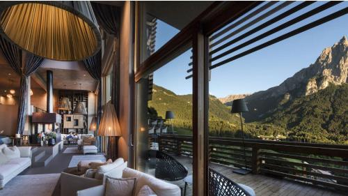 a living room with a view of the mountains at Hotel Valentinerhof in Siusi