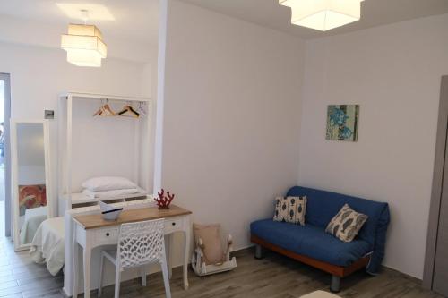 a room with a blue chair and a desk and a bed at Camere Dieci Maggio in Ponza