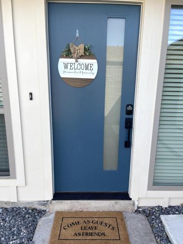 a blue door with a welcome sign on it at Blue Blissful Retreat 3B 2B KING in Richardson