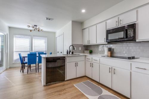 a kitchen with white cabinets and blue chairs in it at Blue Blissful Retreat 3B 2B KING in Richardson