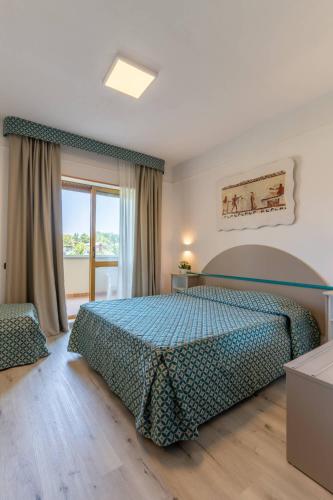 a bedroom with a bed and a large window at Centro Turistico Akiris in Nova Siri Marina