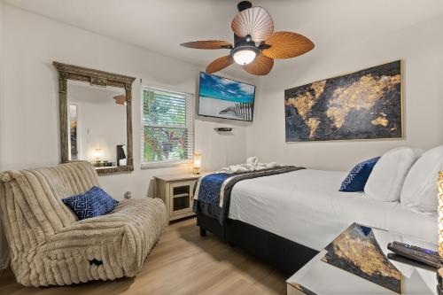 a bedroom with a bed and a chair and a ceiling fan at Luxury Home, Workspace, Movie Room and BBQ in Kissimmee