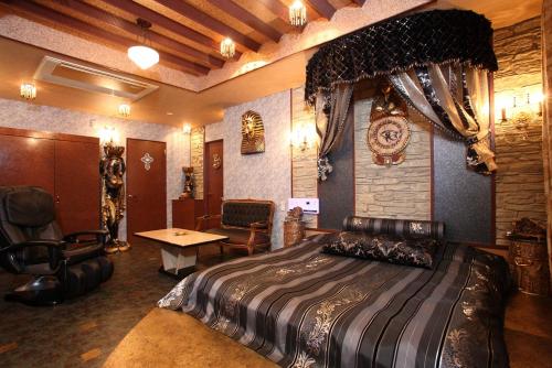 a bedroom with a bed and a desk in a room at ホテル ランドランド -Adult Only- in Yamatotakada