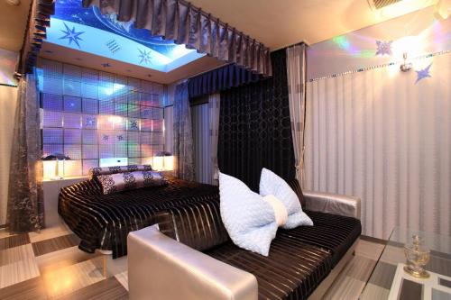 a living room with a couch and a window at ホテル ランドランド -Adult Only- in Yamatotakada