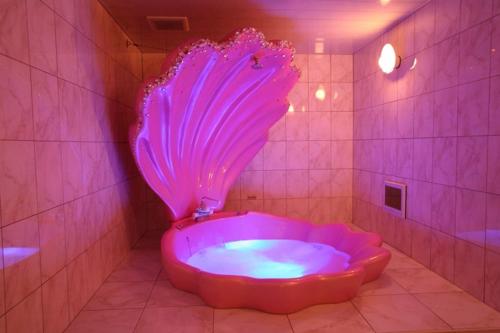 a pink tub in a bathroom with a purple lighting at ホテル ランドランド -Adult Only- in Yamatotakada