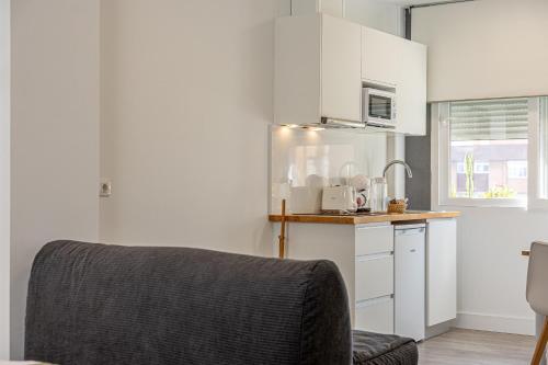a kitchen with white cabinets and a counter top at Bambú Suites Vegueta Alquiler por Habitación in Las Palmas de Gran Canaria