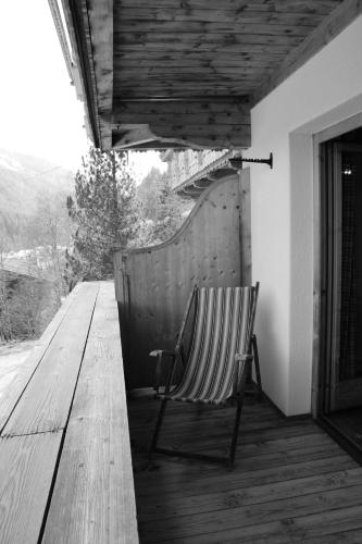 a chair sitting on a porch with a wooden deck at Gästehaus Waldruh in Gerlos
