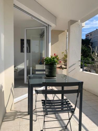 une table noire avec une plante en pot sur un balcon dans l'établissement Grand T2 Pointe Rouge plage, à Marseille