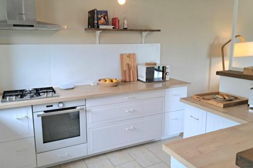 une cuisine avec des armoires blanches et un comptoir dans l'établissement Authentic-Spacious Villa 5 minutes from Sarlat, à Sarlat-la-Canéda