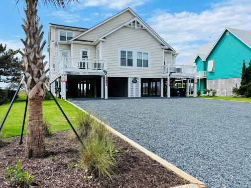 ホールデン・ビーチにあるFINS 1295 Ocean Blvd West homeの前にヤシの木がある家