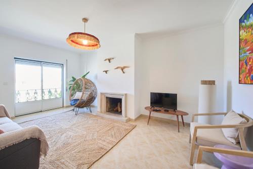 a living room with a couch and a fireplace at Vieira beach house apartment with sea view in Vieira de Leiria
