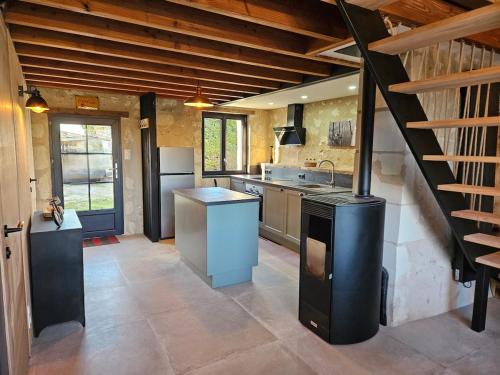 une grande cuisine avec une cuisinière et un escalier dans l'établissement Le Nid Suspendu, à Parçay-les-Pins